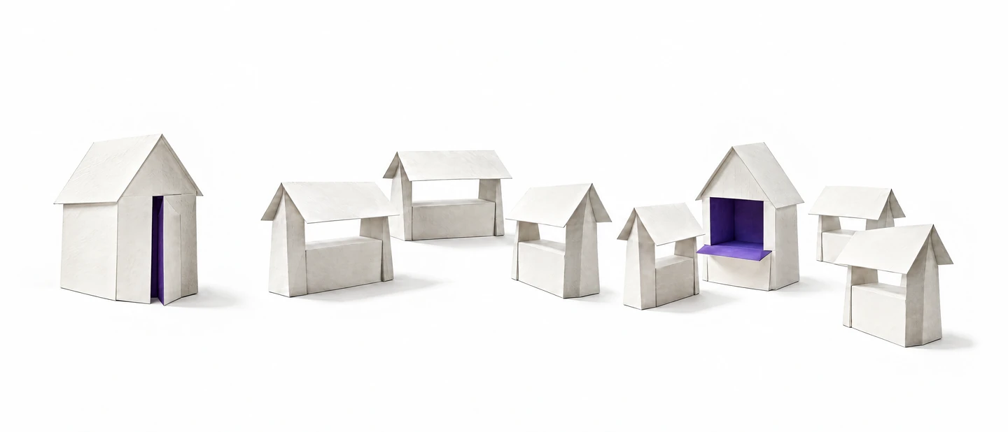 Drei Szenen aus weißem Papier vor Weiß. Links ein einzelnes Giebelhaus, die Tür steht einen Spalt offen, innen ist es violett. In der Mitte drei Marktstände um einen freien Platz. Rechts dasselbe Haus zwischen den Ständen. Seine Front ist heruntergeklappt wie ein Ladentisch, das violette Innere zeigt zum Platz.
